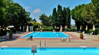 Außenpool mit Liegen und Sonnenschirmen im Ferienpark Camping Mar y Sierra in Marche, Italien, bei Sonne.