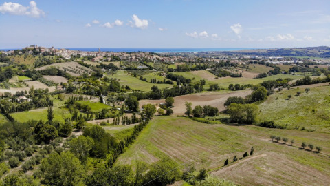 Panoramic view from Camping Mar y Sierra in Marche, Italy, showing rolling hills and a distant village.