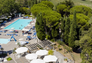 Luftfoto af swimmingpools, liggestole og grønne træer på Camping Mar y Sierra, Marche, Italien.