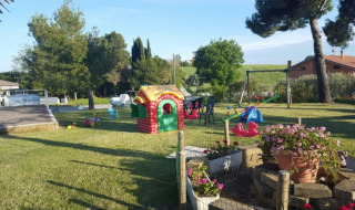 Aire de jeux au Camping Mar y Sierra, parc de vacances dans les Marches, Italie, avec équipements pour enfants.
