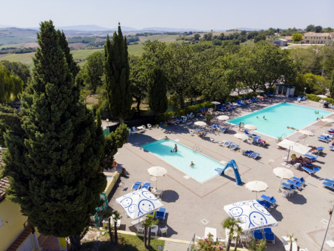Vista aerea del Camping Mar y Sierra con due piscine, lettini e ombrelloni nelle Marche, Italia.