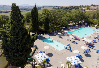 Vista aerea del Camping Mar y Sierra con due piscine, lettini e ombrelloni nelle Marche, Italia.