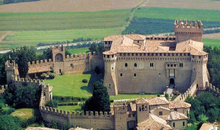 Vista aerea di un castello medievale con mura fortificate circondato da campi vicino a Pesaro, Marche, Italia.