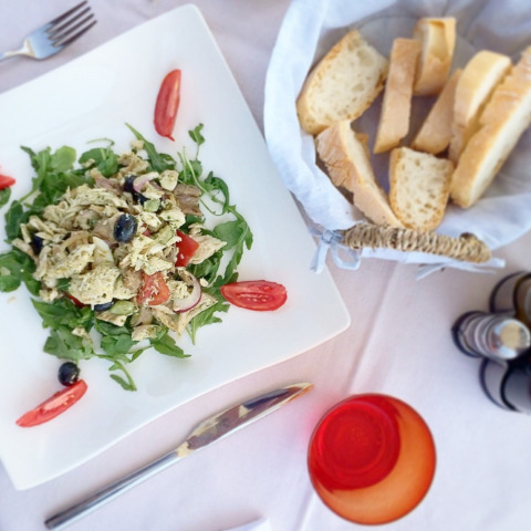 Cibo su un tavolo con pane, insalata e pomodori, foto scattata al Camping Paradiso, Marche, Italia.