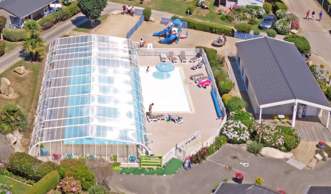 Luftfoto af Camping de Kerleyou i Bretagne, Frankrig, med overdækket pool, børneområde og ferieboliger.