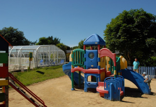 Plastik legeplads på Camping de Kerleyou feriepark i Bretagne, Frankrig, med børn der leger.