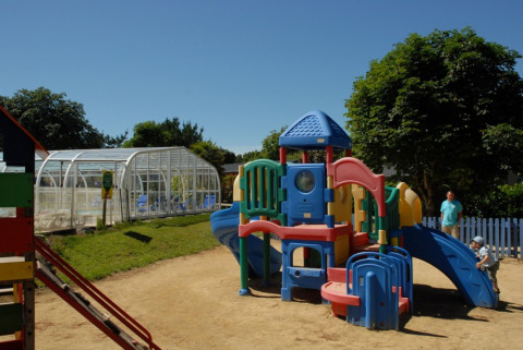 Kunststof speeltuin bij Camping de Kerleyou vakantiepark in Bretagne, Frankrijk, met spelende kinderen.