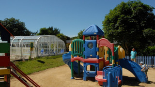 Plastic playground at Camping de Kerleyou holiday park in Brittany, France, with children playing outside.