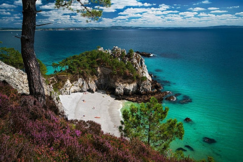 Vista suggestiva di una baia rocciosa con acqua turchese e spiaggia bianca vicino a Douarnenez, Bretagna.