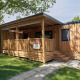 Cabaña de madera SunLodge Katsura en Camping Gasparina, Italia, con terraza y rodeada de vegetación.