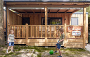 Dos niños juegan con una pelota frente a la cabaña SunLodge Katsura en Camping Gasparina, Italia.