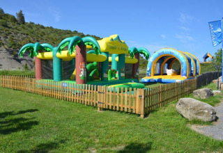 Oppustelig legeplads med jungletema i indhegnet område på Camping Saint Amand, Auvergne-Rhône-Alpes, Frankrig.