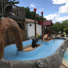 Area giochi d’acqua al Camping Saint Amand, Auvergne-Rhône-Alpes, Francia, con statue e scivoli per bambini.