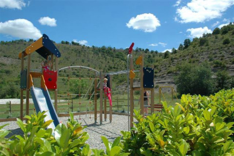 Parque infantil con tobogán y estructura para trepar en Camping Saint Amand, Auvergne-Rhône-Alpes, Francia.