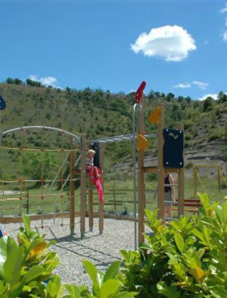 Legeområde med rutsjebane og klatrestativ på Camping Saint Amand i Auvergne-Rhône-Alpes, Frankrig.