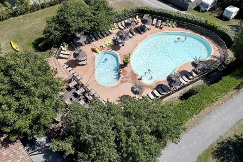 Vista aerea della piscina e dei lettini al Camping Saint Amand, villaggio turistico in Alvernia-Rodano-Alpi, Francia.