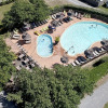 Aerial view of the swimming pool and sun loungers at Camping Saint Amand holiday park in Auvergne-Rhône-Alpes, France.