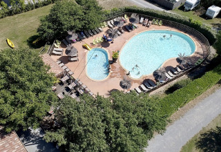 Vista aerea della piscina e dei lettini al Camping Saint Amand, villaggio turistico in Alvernia-Rodano-Alpi, Francia.