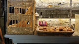 Ceste di pane con baguette e cornetti su un banco al Camping Saint Amand, Auvergne-Rhône-Alpes, Francia.