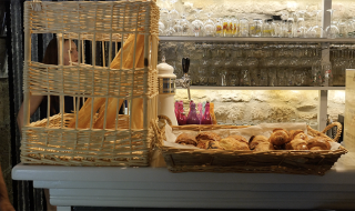 Brødkurve med baguetter og croissanter på en disk i Camping Saint Amand, Auvergne-Rhône-Alpes, Frankrig.