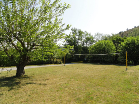 Buitenvolleybalveld bij Camping Saint Amand met gras en bomen in Auvergne-Rhône-Alpes, Frankrijk.