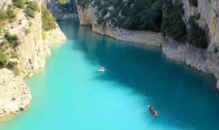 Smuk blå flod omgivet af klipper nær Fréjus i Provence-Alpes-Côte d’Azur, med små både på vandet.