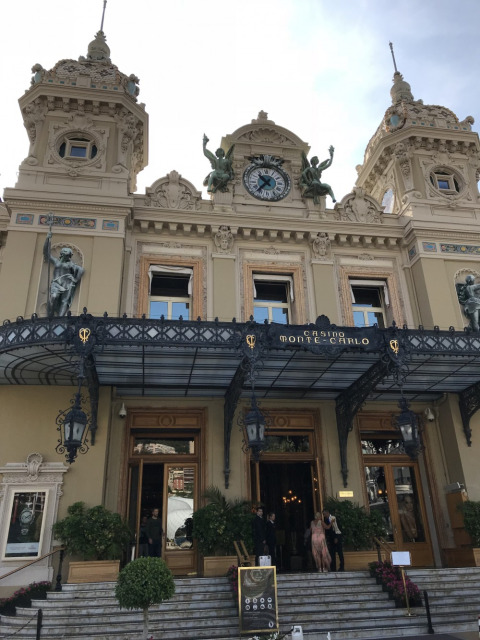 Facciata iconica del Casino de Monte-Carlo con statue e orologio, vista dalla scalinata principale d'ingresso.