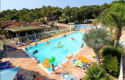 Outdoor swimming pool with people relaxing and swimming at Camping Les Lauriers Roses, Provence-Alpes-Côte d’Azur, France.