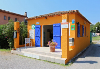 Bunte orangefarbene Rezeption mit blauen Fensterläden im Camping Les Lauriers Roses in Südfrankreich.