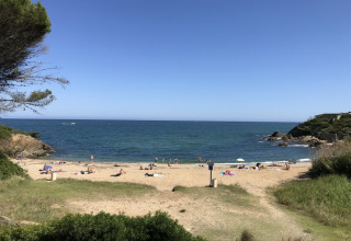 Udsigt over sandstrand og hav ved Camping Les Lauriers Roses i Provence-Alpes-Côte d’Azur, Frankrig.