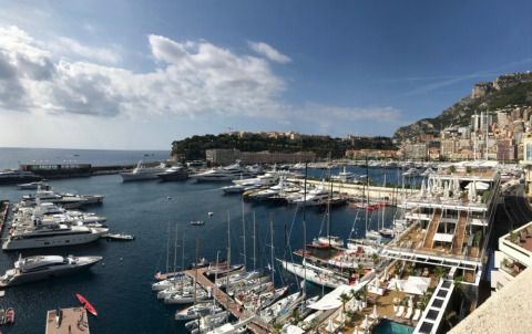 Vista de un puerto deportivo con yates de lujo, ciudad y montañas en Provence-Alpes-Côte d’Azur, Francia.
