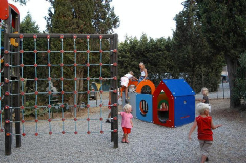 Bambini giocano su un’area giochi con arrampicata e casetta al Camping Les Lauriers Roses, Provenza, Francia.
