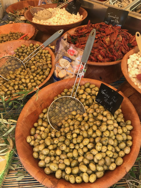 Various bowls of olives, cheese, and sun-dried tomatoes at a market in Provence-Alpes-Côte d’Azur, France.
