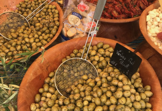 Varie ciotole di olive, formaggi e pomodori secchi al mercato in Provence-Alpes-Côte d’Azur, Francia.