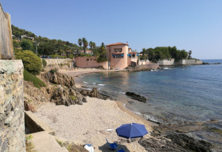 Visning af en strand og et feriehus ved Camping Les Lauriers Roses i Provence-Alpes-Côte d’Azur, Frankrig.