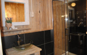 Badkamer in safaritent bij Camping Roland in Nederland met glazen waskom en moderne douche.