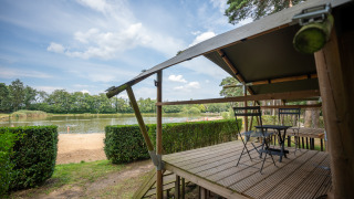 Vista desde Duo Lodge en Familiepark Goolderheide, Bélgica, con terraza y lago en el fondo.