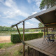 Udsigt fra Duo Lodge ved Familiepark Goolderheide i Belgien med veranda og sø i baggrunden.