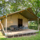 Safari-telt Lake med terrasse og havemøbler, omgivet af træer og grøn natur, perfekt til glamping.