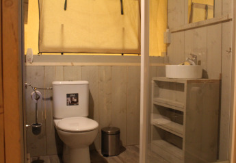 Bagno in una tenda safari con WC, lavandino e specchio al Familiepark Goolderheide, Belgio.