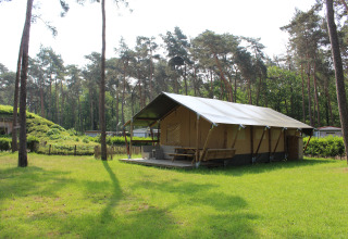 Tenda safari con servizi igienici e scivolo al Familiepark Goolderheide in Belgio, immersa tra gli alberi.