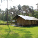 Safari-Zelt mit Sanitäranlagen und Rutsche im Familiepark Goolderheide in Belgien, umgeben von Wald.
