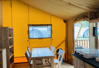 Interno di una tenda safari con sala da pranzo in legno a Familiepark Goolderheide, Belgio.