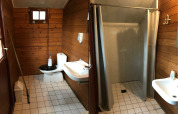 Baño de tienda safari en Familiepark Goolderheide, Bélgica, con inodoro, lavabo y ducha con cortina.