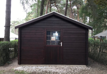 Capanno di legno con porta e finestra, circondato da foresta al Safari tent + sanitary presso Familiepark Goolderheide, Belgio.