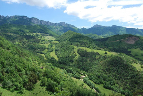 Vista panorámica de colinas y montañas verdes en Camping Le Gallo Romain en Auvergne-Rhône-Alpes, Francia.