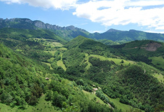 Smukt udsyn over grønne bakker og bjerge ved Camping Le Gallo Romain i Auvergne-Rhône-Alpes, Frankrig.