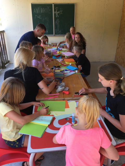 Niños y adultos disfrutan de actividades creativas en Camping Le Gallo Romain, Auvergne-Rhône-Alpes, Francia.