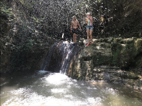 Dos personas se refrescan bajo una cascada cerca de Barbières, en la región de Auvergne-Rhône-Alpes, Francia.