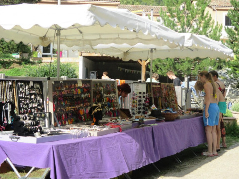 Mercatino di gioielli all'aperto a Camping Le Gallo Romain, Auvergne-Rhône-Alpes, Francia, con visitatori.